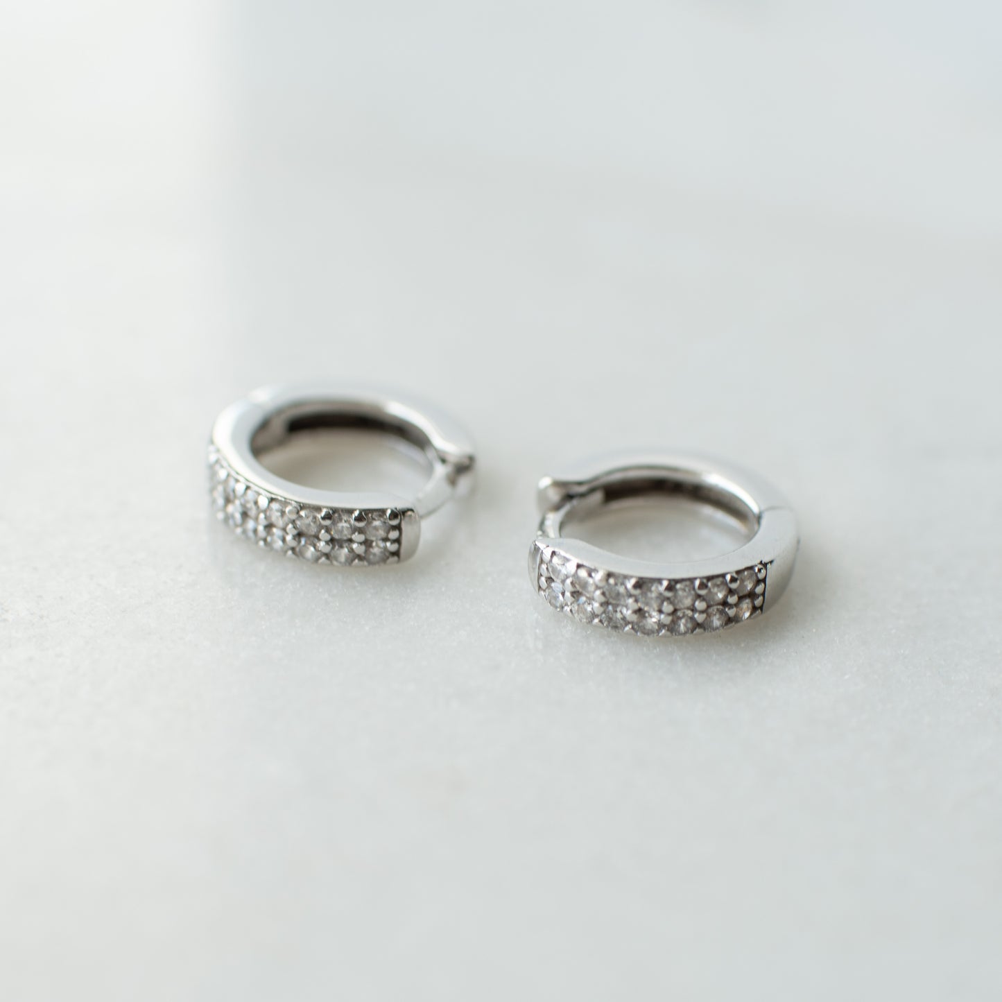 Cubic zirconia encrusted silver huggie hoops