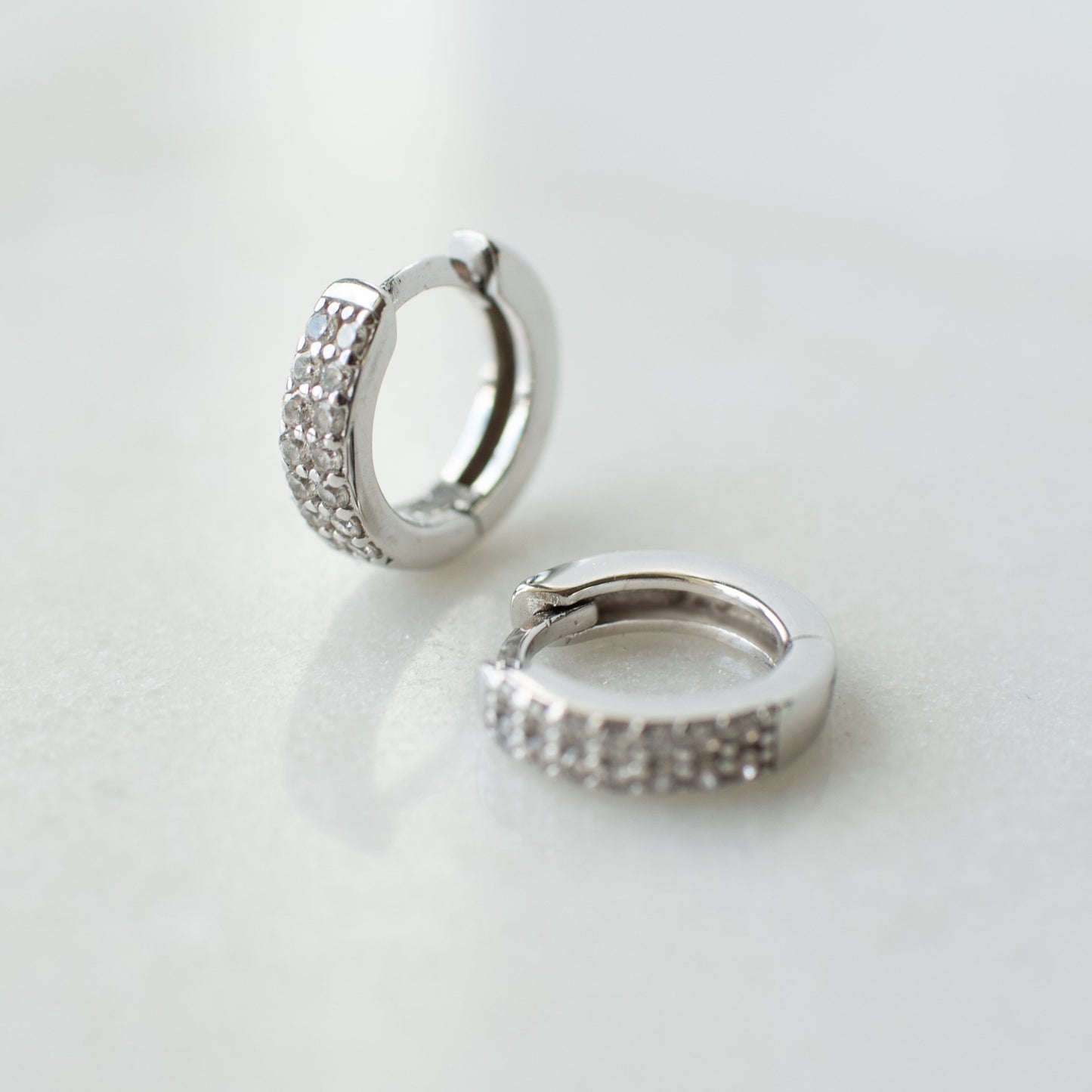 Cubic zirconia encrusted silver huggie hoops