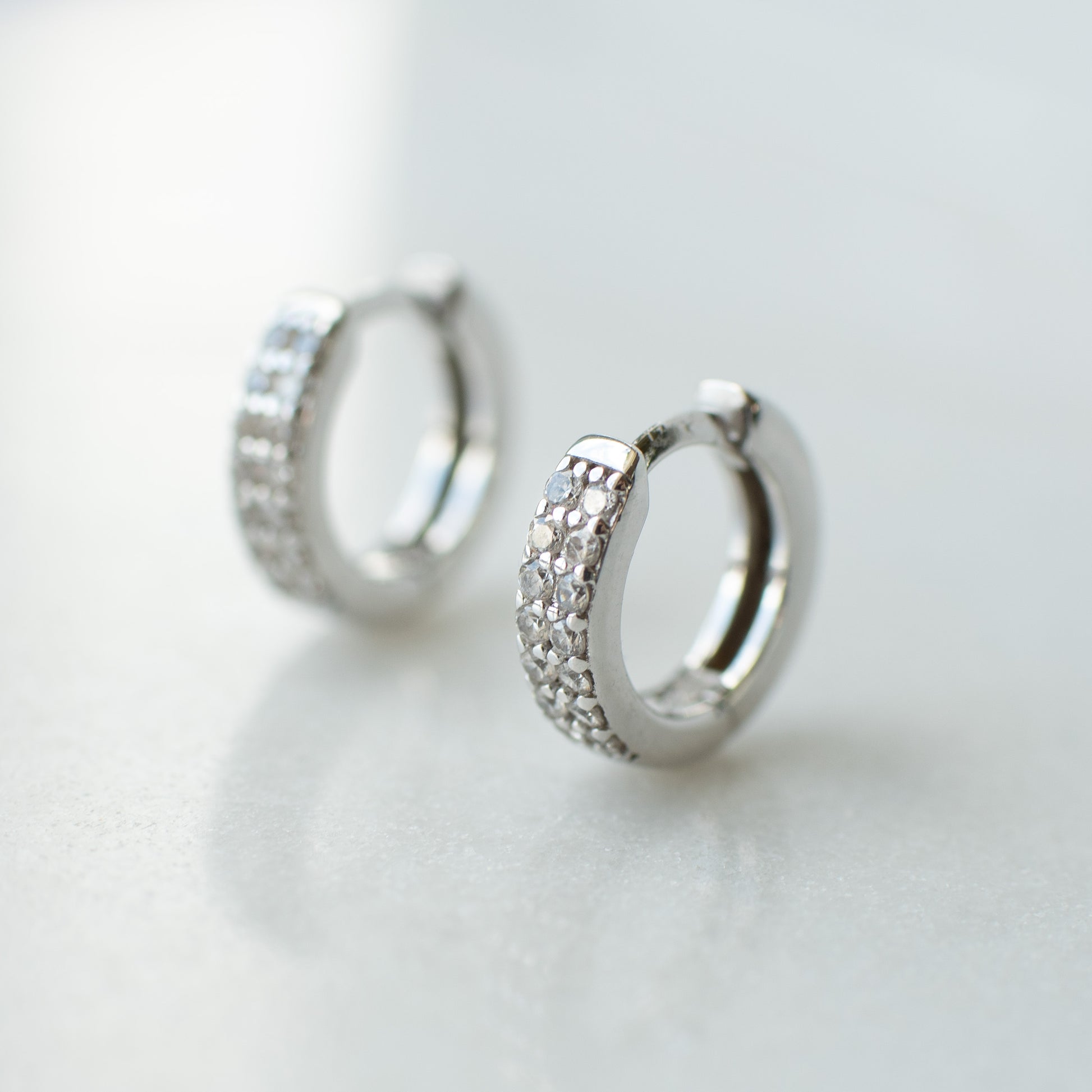 Cubic zirconia encrusted silver huggie hoops