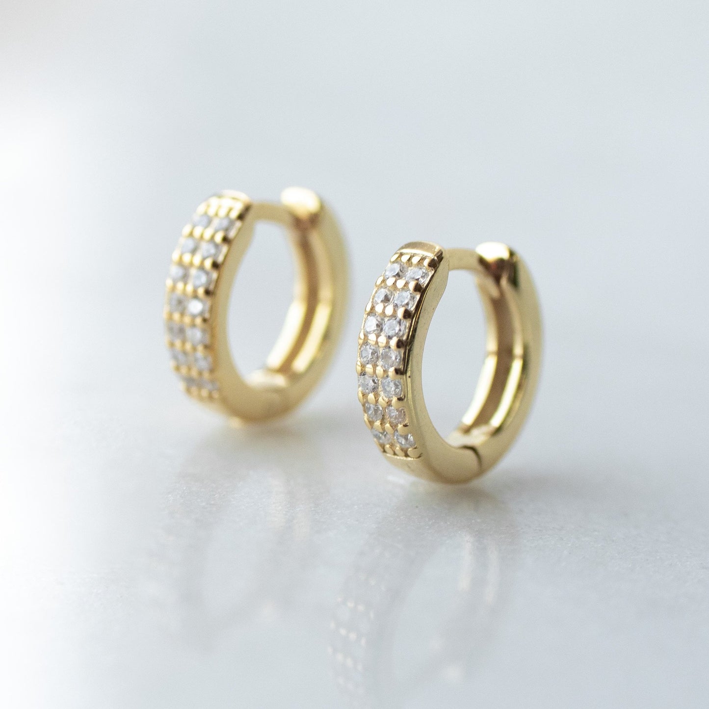 Cubic zirconia encrusted gold huggie hoops