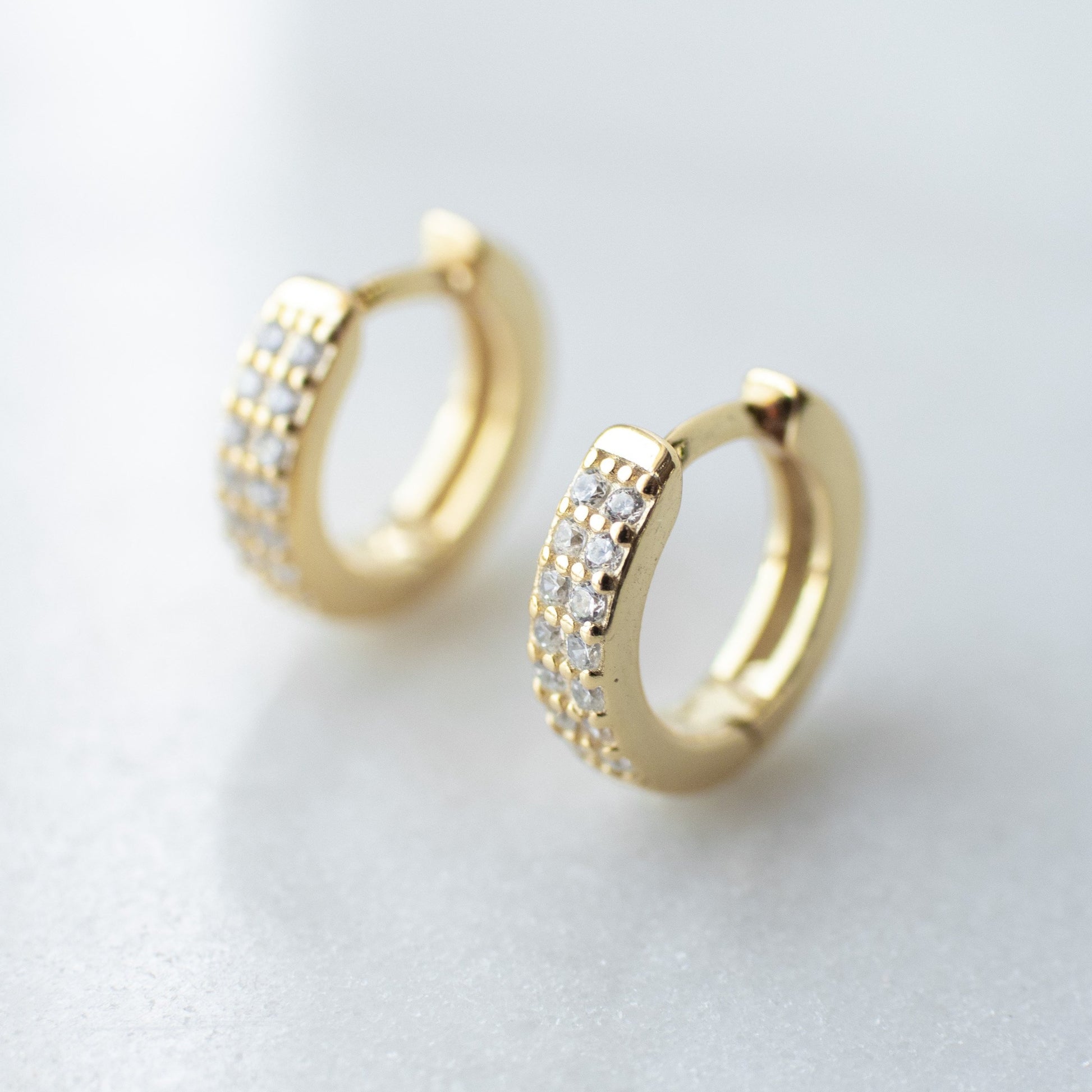 Cubic zirconia encrusted gold huggie hoops