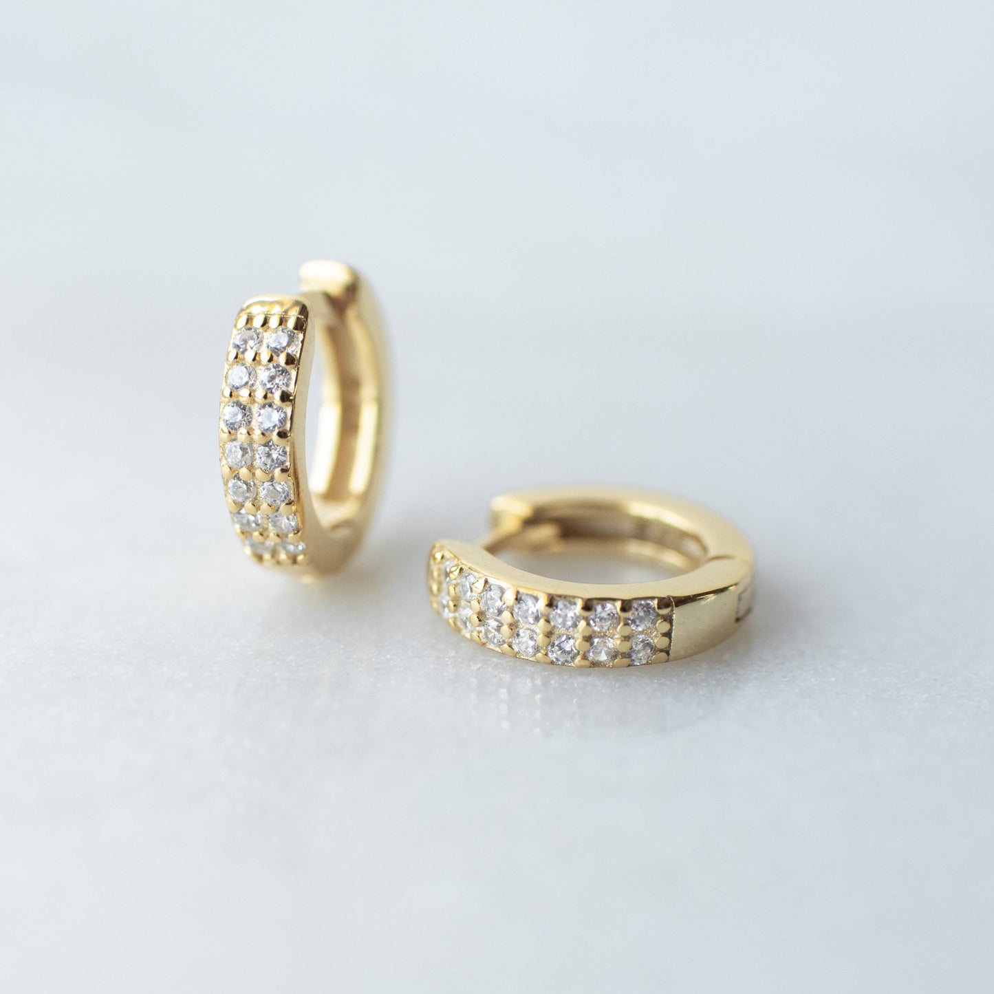 Cubic zirconia encrusted gold huggie hoops